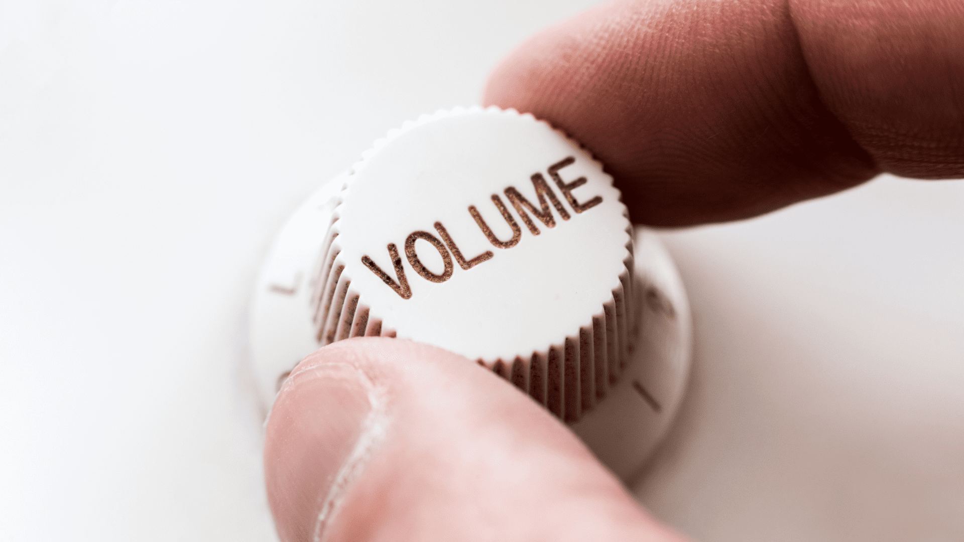 A person holding a 'volume' dial