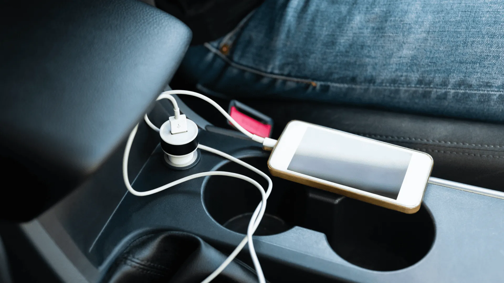 Phone plugged into charger sitting on car console